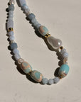 Necklace with blue and white beads on a beige background