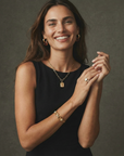 Woman wearing gold jewelry against a dark background