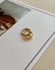 Two gold rings on a white card with a blurred background