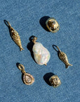 Collection of gold and pearl jewelry on a blue denim background