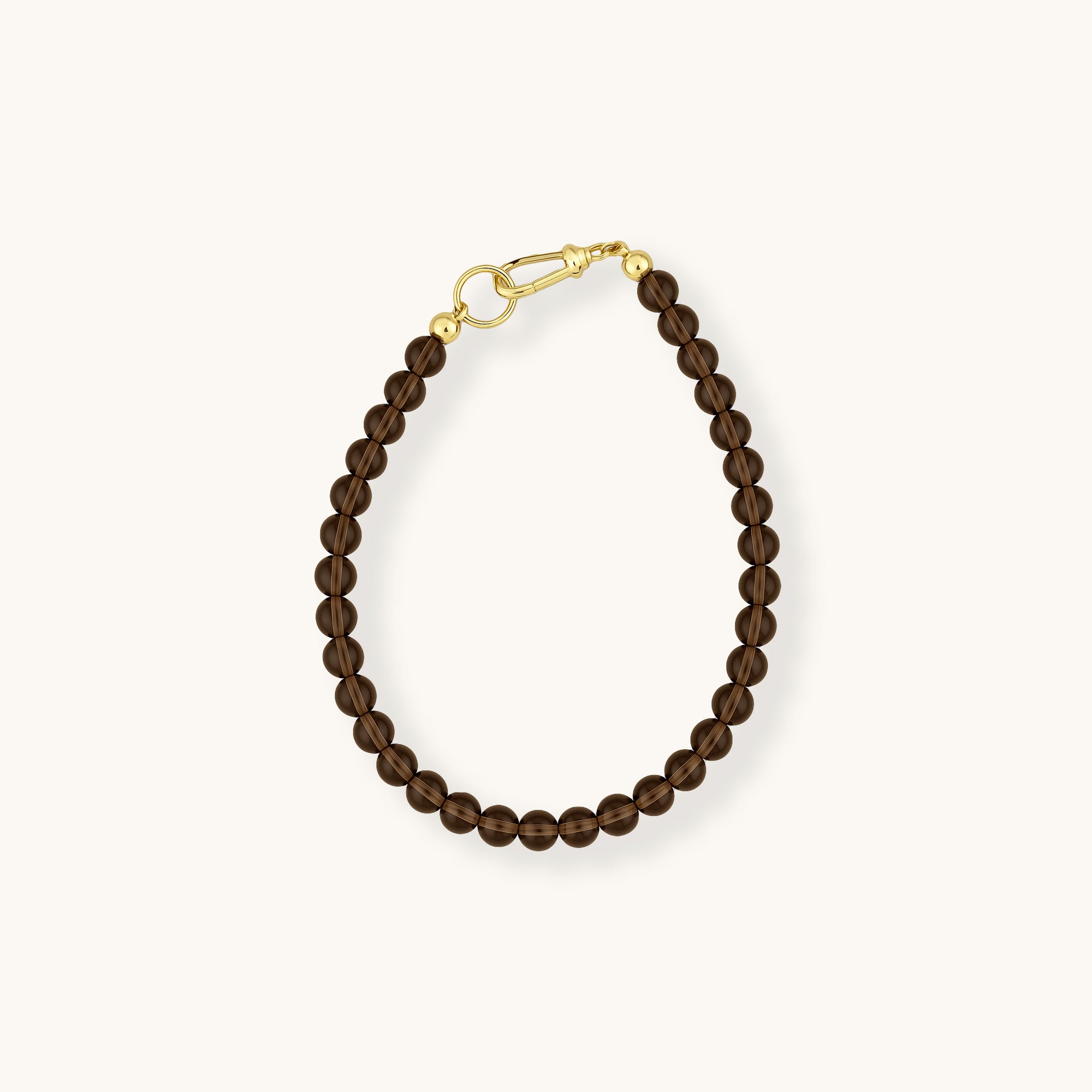 Brown beaded bracelet with gold clasp on a white background