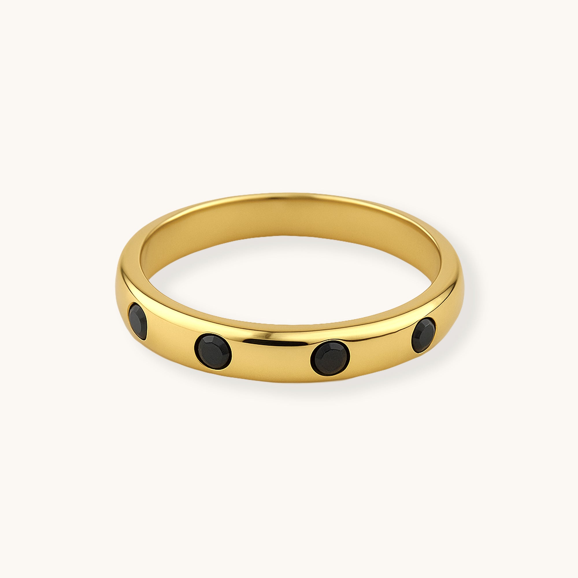 Gold ring with black stones on a white background