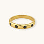 Gold ring with black stones on a white background