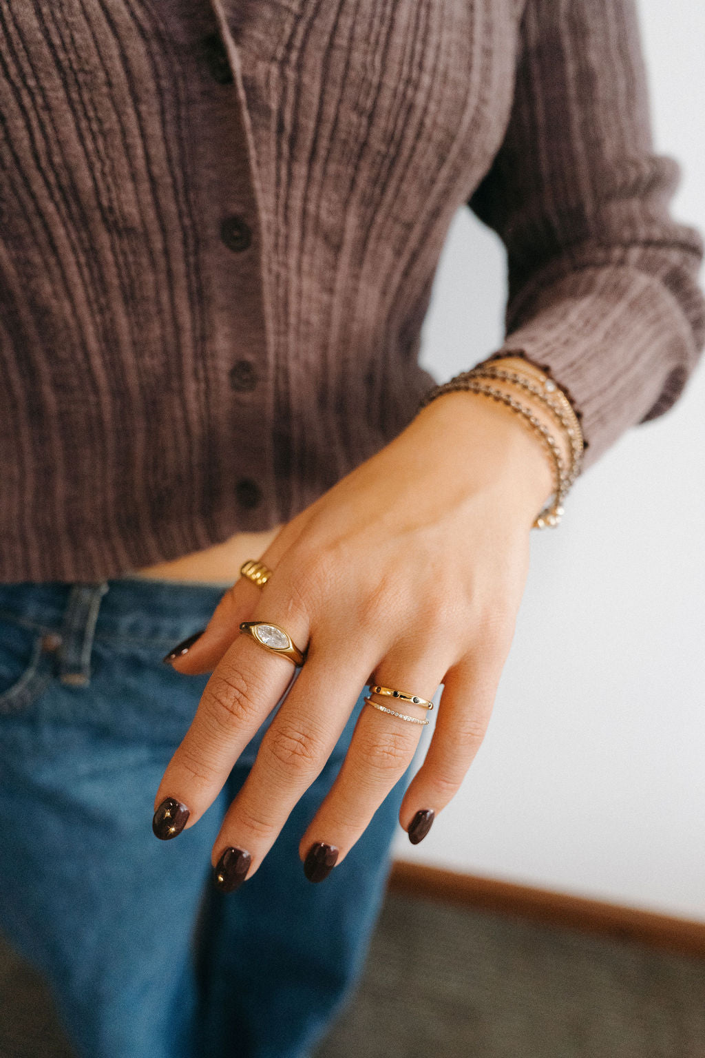 Close-up of a hand wearing multiple rings with a blurred background