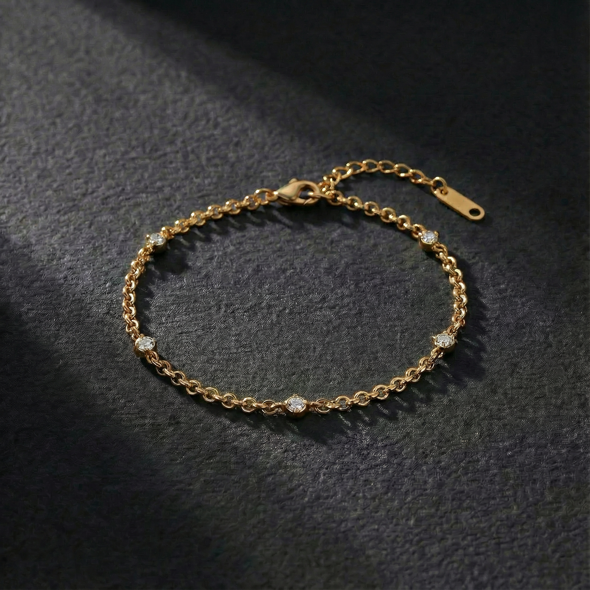 Gold bracelet with small diamonds on a dark textured surface
