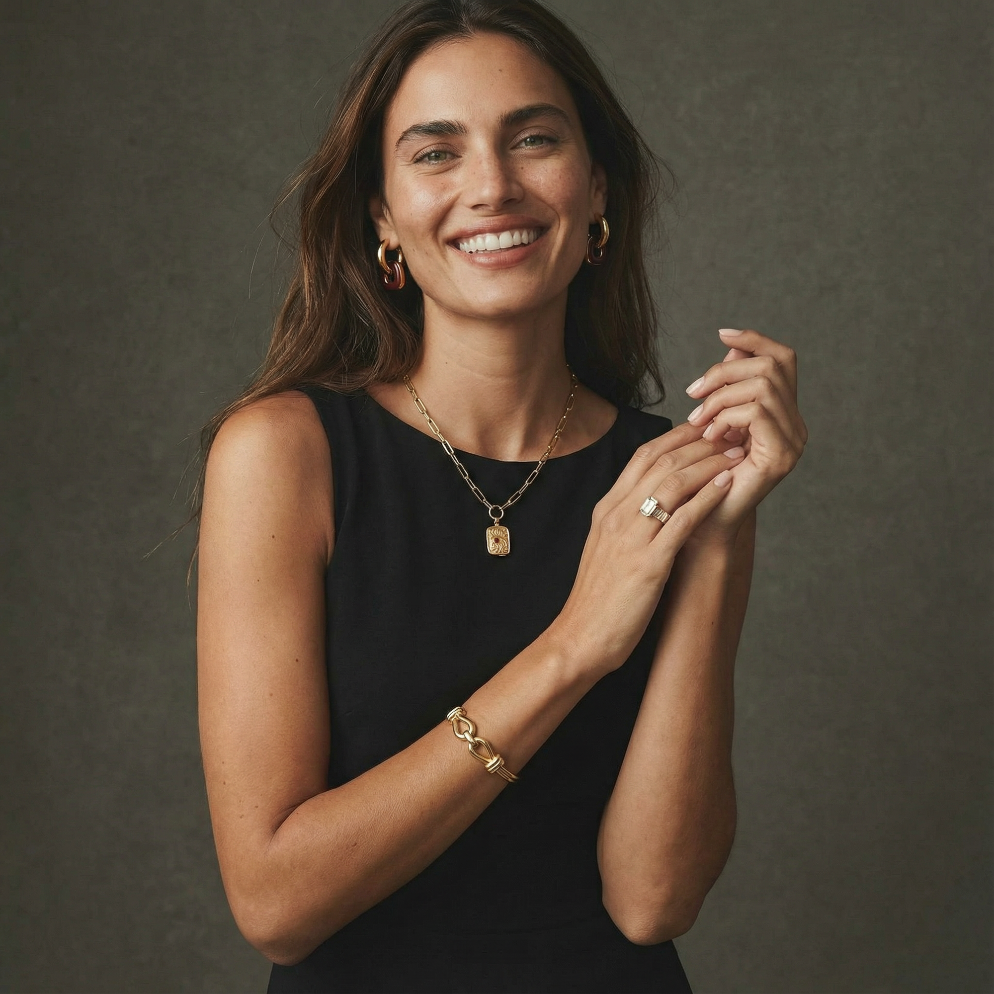 Woman wearing gold jewelry against a dark background