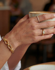 Hand holding a ceramic cup with jewelry on a blurred background