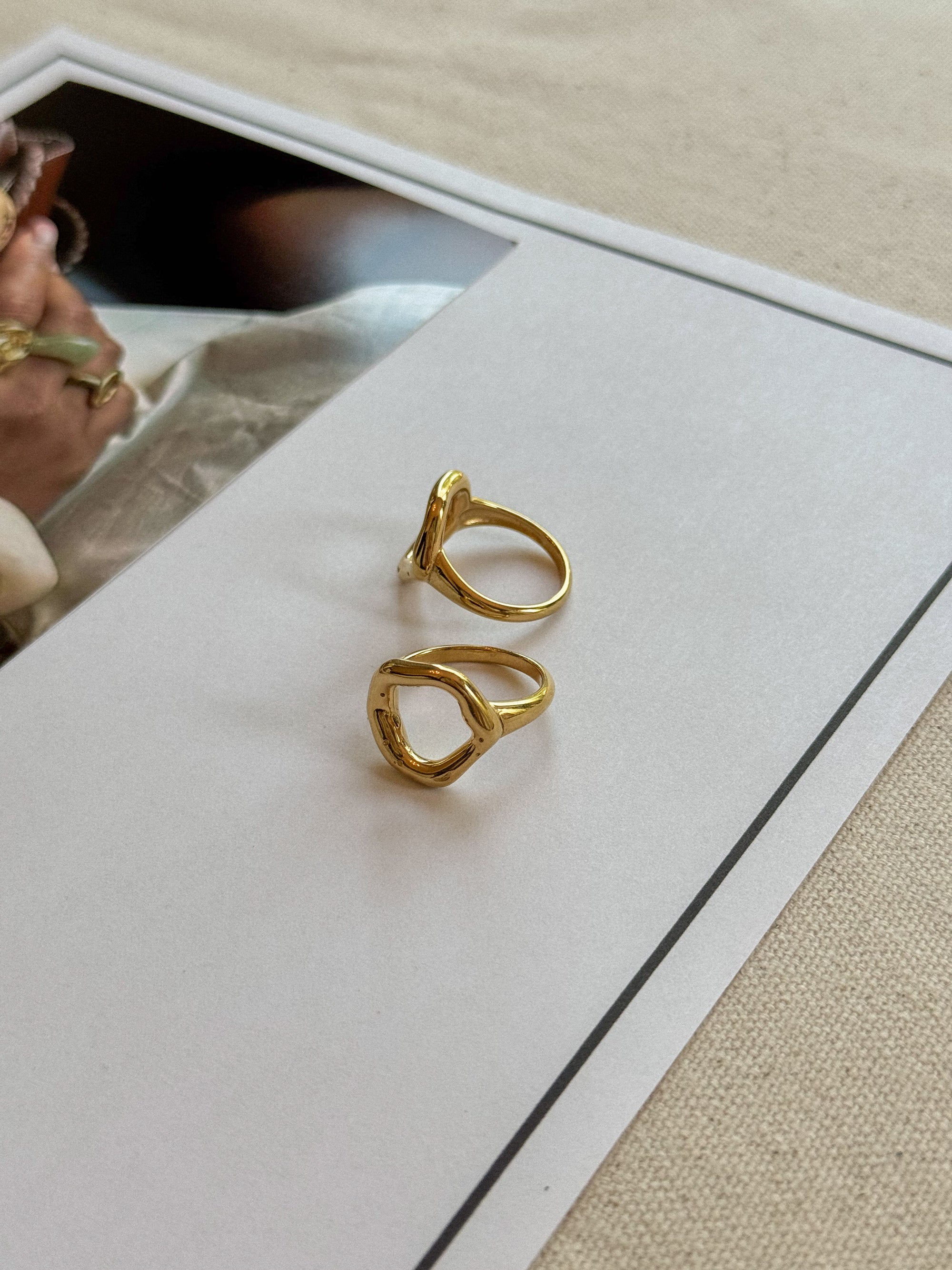 Gold earrings on a white card with a blurred background