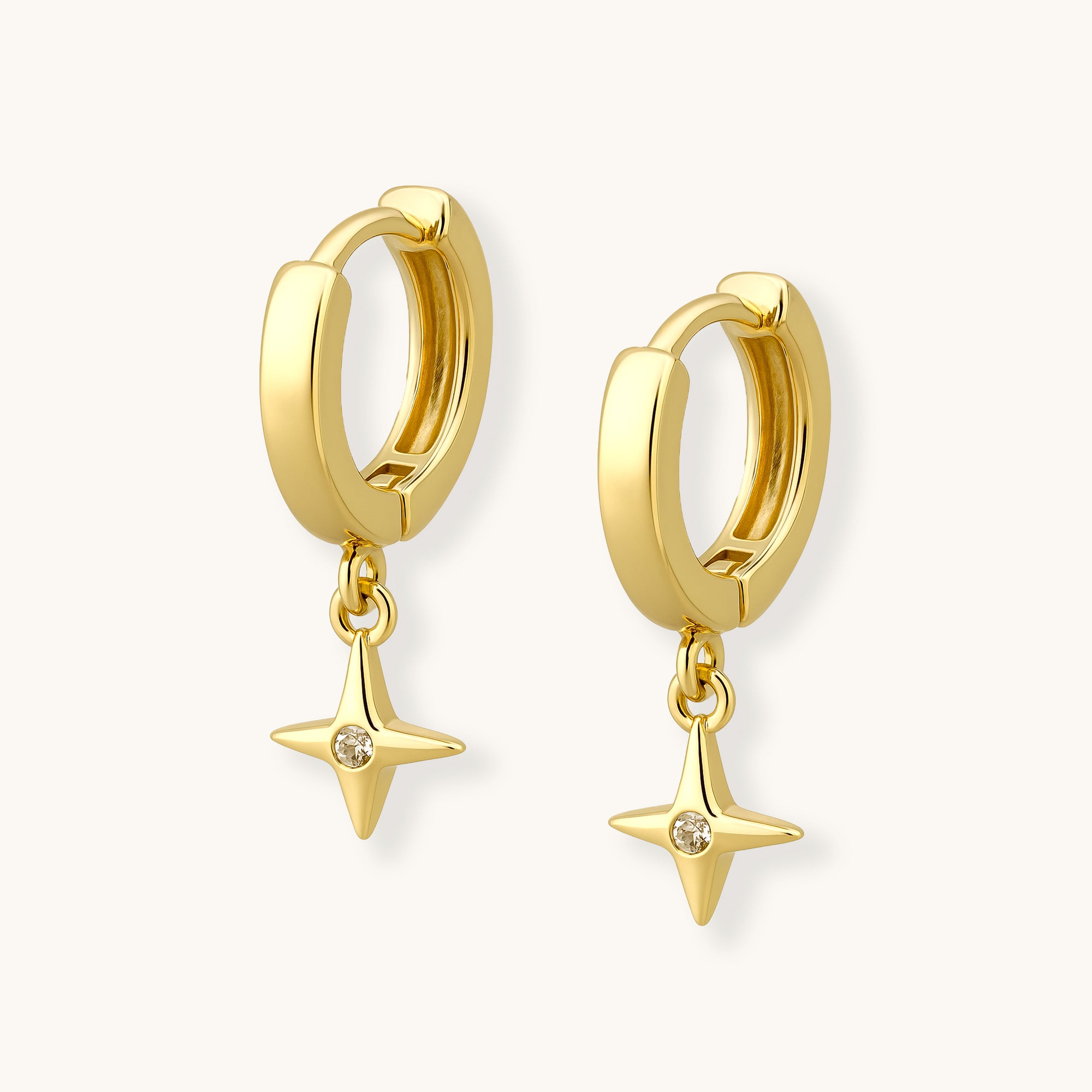 Gold hoop earrings with star-shaped charms on a white background