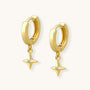 Gold hoop earrings with star-shaped charms on a white background