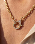 Gold necklace with a heart-shaped pendant on a person's neck