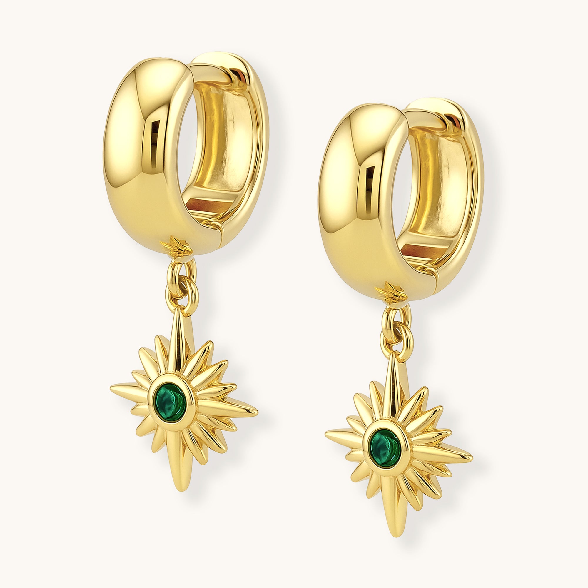 Gold hoop earrings with sunflower-shaped charms featuring green gemstones on a white background.