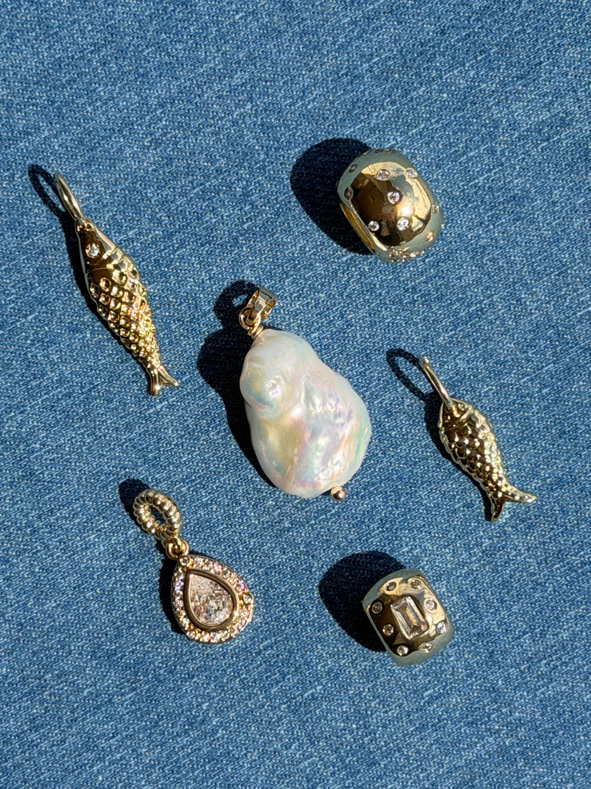 Collection of gold and pearl jewelry on a blue denim background