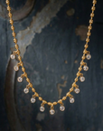 Gold necklace with crystal beads on a textured dark background