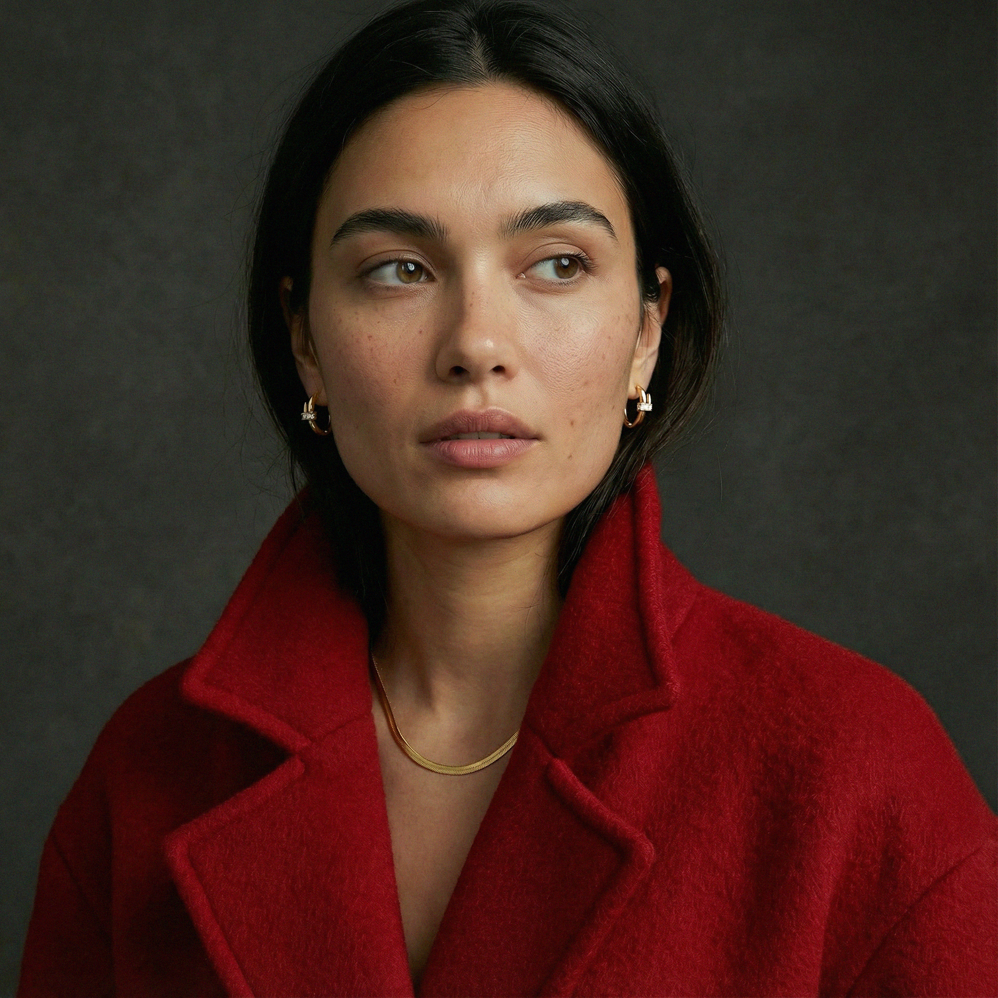 Woman wearing a red coat against a dark background