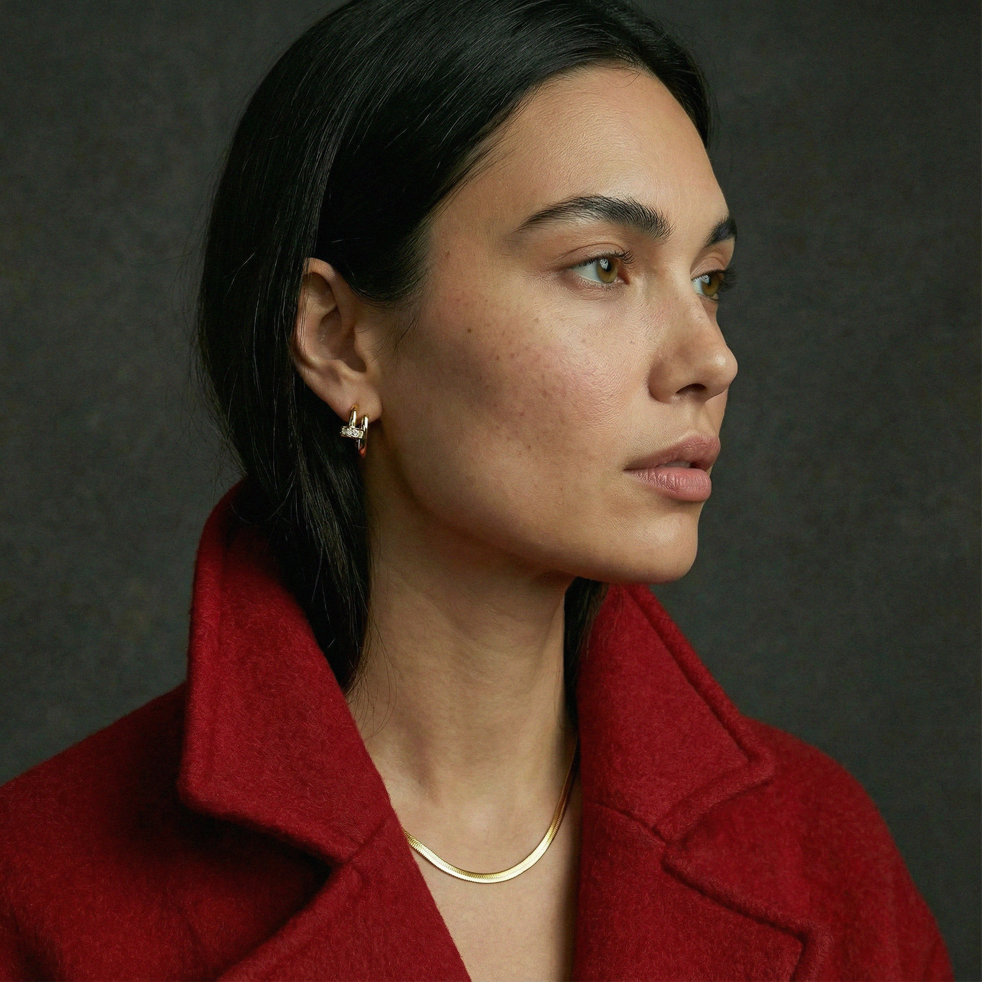 Woman wearing a red coat with a dark background